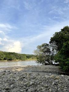 a river with rocks and trees in the background at Paraiso del Cauca in Jericó