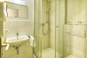 a bathroom with a glass shower and a sink at Hotel Sonne in Staufen im Breisgau