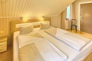 a bedroom with two beds with a chair in it at Hotel Sonne in Staufen im Breisgau