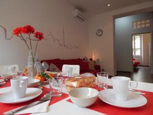 Red Flat In Rome في روما: طاولة مع قماش الطاولة الحمراء مع الأطباق والأكواب