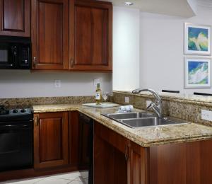 a kitchen with wooden cabinets and a sink at Naples Bay Resort and Marina in Naples