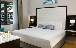 a bedroom with a large white bed and a window at Naples Bay Resort and Marina in Naples