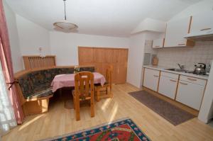 a kitchen with a table and a couch in a room at Haus Charlotte in Kals am Großglockner