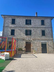 a large stone building with a large wooden door at Il Casale Appartamento Assisi in Assisi