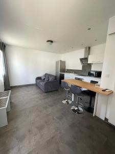 a kitchen and living room with a table and a couch at Brit Hotel Marvejols in Marvejols
