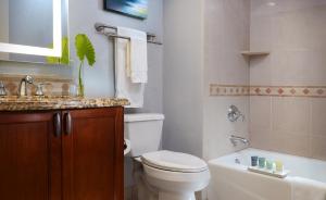 a bathroom with a toilet and a sink and a tub at Naples Bay Resort and Marina in Naples