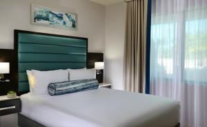 a bedroom with a large white bed with a green headboard at Naples Bay Resort and Marina in Naples