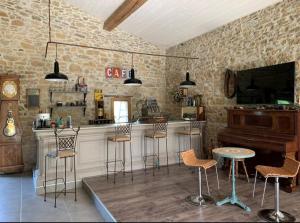 eine Bar mit Stühlen und einem Klavier in einem Raum in der Unterkunft Bulle perchée in Sonnac-sur-lʼHers