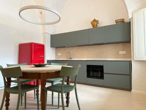 a kitchen with a table and chairs and a red refrigerator at Casetta di Tiggiano - Boutique house in Tiggiano +16 photos