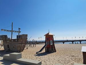 a playground on the beach next to a pirate ship at Meerblick 5 - Großenbrode in Grossenbrode +13 photos
