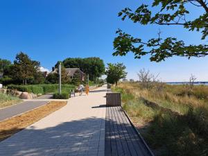 a sidewalk with people walking on it next to a field at Meerblick 5 - Großenbrode in Grossenbrode