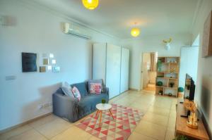 un salon avec un canapé bleu et une table dans l'établissement Seaview terrace, 2bedrooms, communal pool COGO1-1, à Sliema