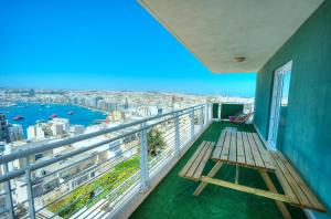 d'un balcon avec un banc et une vue sur la ville. dans l'établissement Seaview terrace, 2bedrooms, communal pool COGO1-1, à Sliema