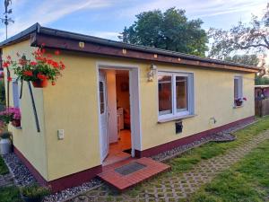 ein kleines Haus in einem Hof mit einer Tür in der Unterkunft Ferienbungalow Jahnke auf Usedom mit Wlan in Zirchow