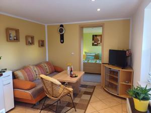 ein Wohnzimmer mit Couch und Fernseher in der Unterkunft Ferienbungalow Jahnke auf Usedom mit Wlan in Zirchow