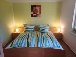 Schlafzimmer mit einem Bett mit bunter Bettwäsche und Kissen in der Unterkunft Ferienbungalow Jahnke auf Usedom mit Wlan in Zirchow