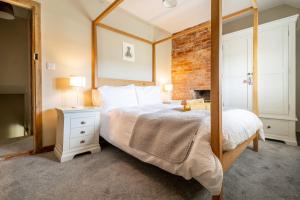 ein Schlafzimmer mit einem großen Bett und einem Spiegel in der Unterkunft Willow Cottage SC in South Creake