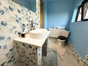 a bathroom with a sink and a toilet at Golden Escape - Charming Studio in Prime Location in Craiova