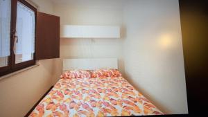 a bed in a room with a bedspread on it at Mimosa in Acquaseria