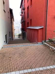 an alley with a red building and a brick sidewalk at Mimosa in Acquaseria