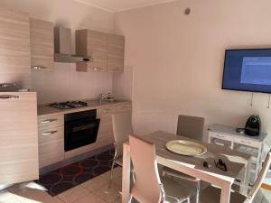 a kitchen with a table and a television in it at Mimosa in Acquaseria