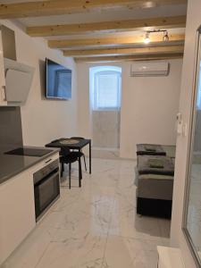 a kitchen and living room with a table and a couch at Apartment Rose Cres 4 in Cres +6 photos