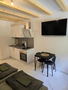 a kitchen with a table and a television on the wall at Apartment Rose Cres 4 in Cres