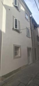 a white building with two windows and a door at Apartment Rose Cres 4 in Cres