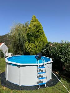 a hot tub in the yard with a ladder next to it at Casa da avó Delmira in São Marcos da Serra