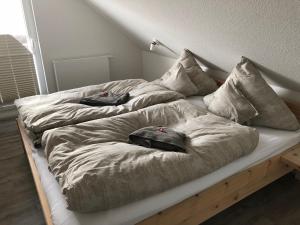 a bed with two pillows on top of it at "Sonne auf der Haut" - Residenz Glücksmomente 1OG in Langeoog