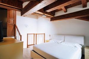 Saint MarcelにあるAosta Holiday Apartments - La Plantazの白いベッドと木製の天井が備わるベッドルーム1室が備わります。