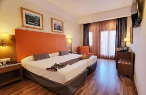 a hotel room with a large bed and a chair at Hotel Monarque Costa Narejos in Los Alcázares