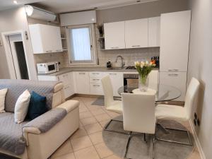 a kitchen and living room with a table and a couch at LA MAR Apartment Zelarino in Zelarino +12 photos
