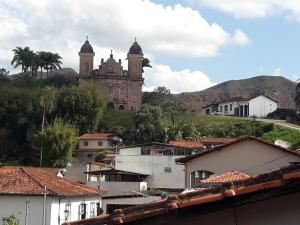 an old building with two towers on a hill at Loft Reservado em Mariana in Mariana