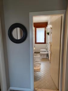 a bathroom with a toilet and a mirror on the door at LA MAR Apartment Zelarino in Zelarino