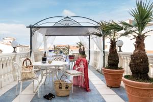 a patio with a table and chairs on a balcony at Hotel London in Viareggio