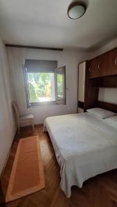 a bedroom with a large bed and a window at APARTMAN LUCIA in Ražanac