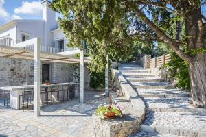 een patio met een tafel en een boom bij Villa Giovannina in Perama