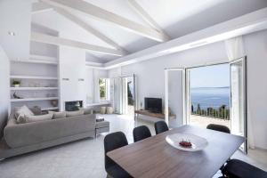 een woonkamer met een tafel en een bank bij Villa Giovannina in Perama