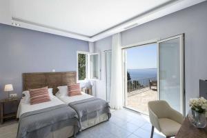 een slaapkamer met een bed en uitzicht op de oceaan bij Villa Giovannina in Perama +26 foto's