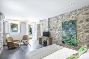 een slaapkamer met een bed en een stenen muur bij Villa Giovannina in Perama