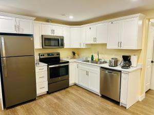 a kitchen with white cabinets and stainless steel appliances at Luxurious Basement Retreat in Charlottetown