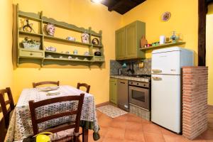 a kitchen with a table and a white refrigerator at Green Home in Ronciglione