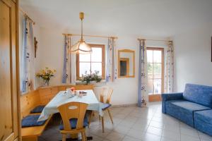 ein Wohnzimmer mit einem Tisch und einem blauen Sofa in der Unterkunft Bärntalerhof in Pfalzen