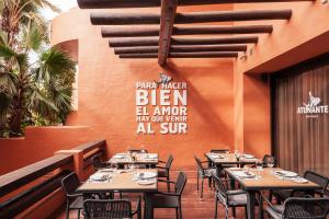a restaurant with tables and chairs and a wall at Royal Hideaway Sancti Petri in Chiclana de la Frontera