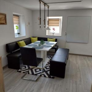 a dining room with a white table and black chairs at Ferienparadies Haus Monica in Weikertsham