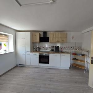 a white kitchen with white appliances and a window at Ferienparadies Haus Monica in Weikertsham +14 photos