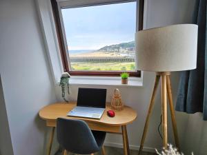 a desk with a laptop computer on it next to a window at Ocea Marina appartement vue mer refait à neuf avec parking privatif in Deauville