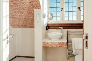 a bathroom with a sink and a mirror at Fanhams Hall, Exclusive Collection in Ware