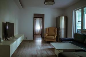 巴克乌Lion Crib的客厅配有电视、沙发和椅子